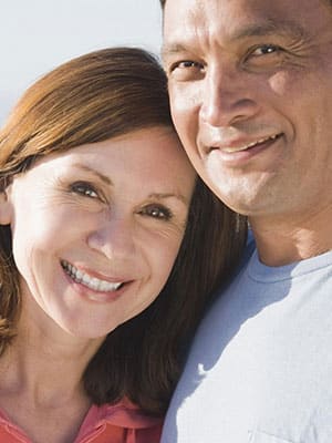 Happy middle-aged couple embracing outdoors.