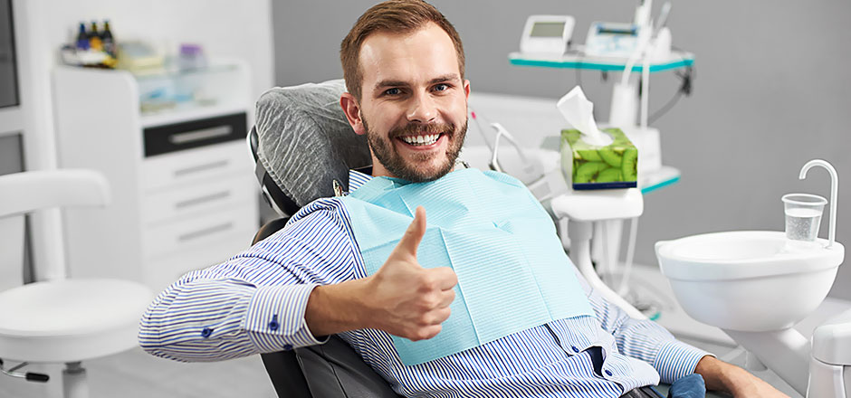 patient gives thumbs-up to dental cleaning